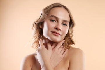Fototapeta premium Portrait of beautiful woman on beige background