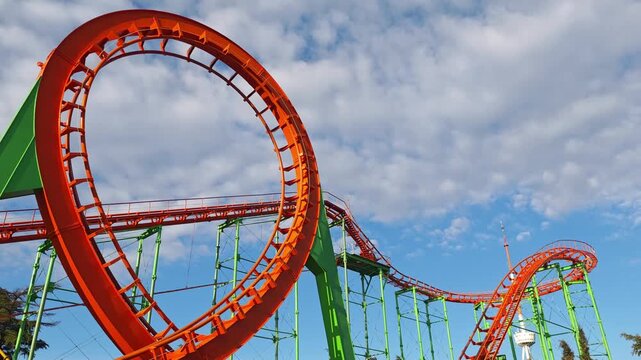Exciting roller coaster with a massive loop and winding tracks providing a thrilling ride at a funfair under a partly cloudy sky