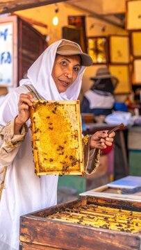 Beekeeper Holding Honeycomb Frame with Bees in Market.