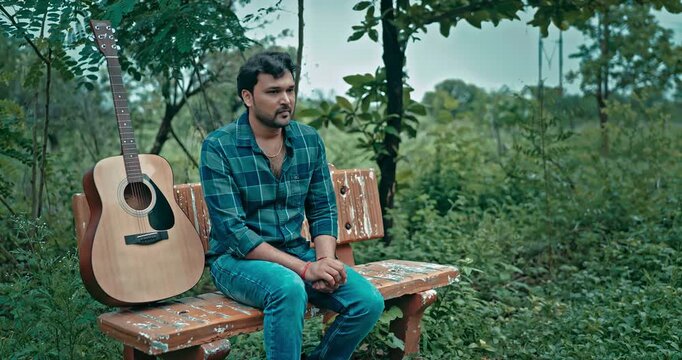 An emotional romantic scene where a man waits patiently for his girlfriend with a guitar, and after she arrives late, she lovingly apologizes and wins him back with affection