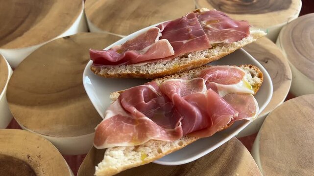 Tostadas de jam&oacute;n serrano con aceite de oliva girando en base giratoria