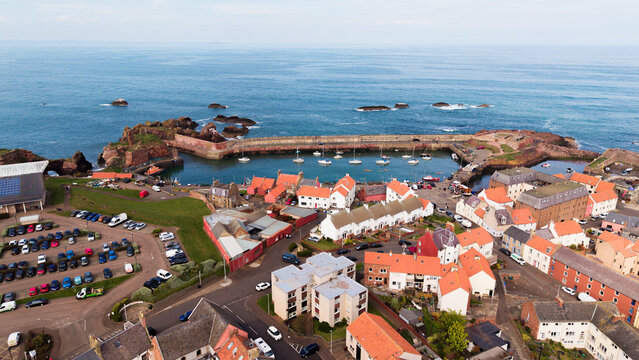Aerial view of Dunbar harbour and coastal town architecture with traditional stone houses along the North Sea in East Lothian Scotland