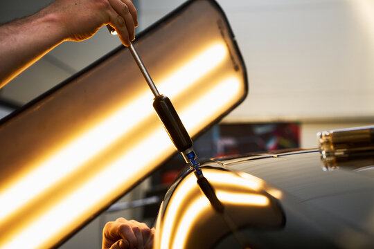 PDR active glue pulling. Dynamic slide hammer used in paintless dent repair for tabs.