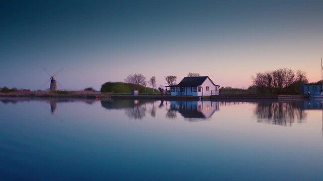 The Norfolk Broads River Bure in Thurne, English countryside rural scene with windmill