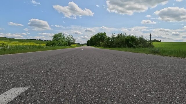 Video shooting in motion, driving a red car over the road along the asphalt at speed, view from the wheel.