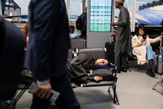 Sleeping, jet lag and woman on airport bench waiting for flight, passing time. Taking nap, chairs and bored girl in departure hub waiting for plane taking her to travel destination