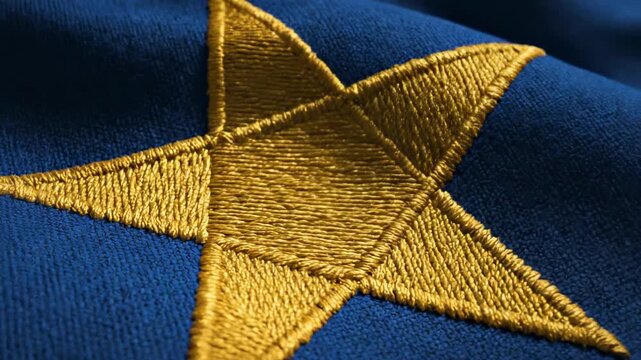 This features a close-up shot of a gold star embroidered on blue fabric, commonly used as an emblem or logo in press conferences and official events.