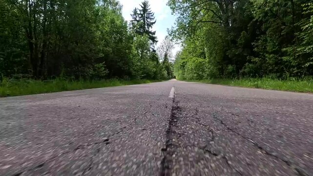 Video shooting in motion, driving a red car over the road along the asphalt at speed, view from the wheel.
