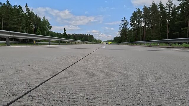 Video shooting in motion, driving a red car over the road along the asphalt at speed, view from the wheel.
