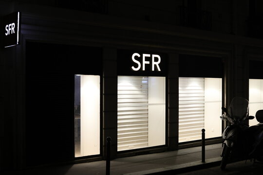 Paris, France - February 23, 2026. A closed and illuminated SFR store by night.