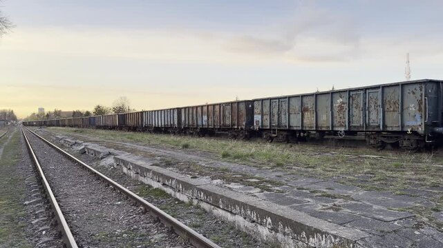 Abandoned rusty freight train wagons line panning