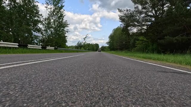 Video shooting in motion, driving a red car over the road along the asphalt at speed, view from the wheel.