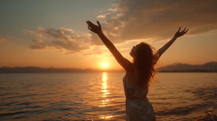 Fototapeta premium Sunset Serenity: A woman stands with open arms, embracing the golden hues of a setting sun over tranquil waters, a moment of peace and freedom.