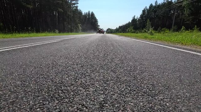 Video shooting in motion, driving a red car over the road along the asphalt at speed, view from the wheel.
