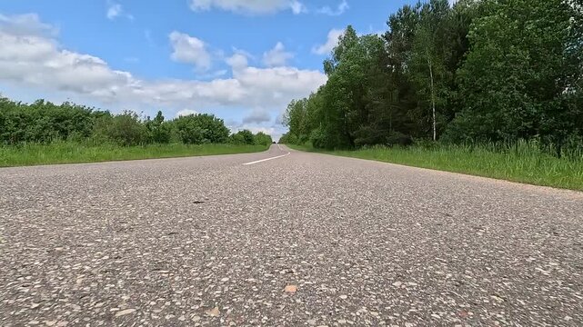 Driving a red car over the road along the asphalt at speed, view from the wheel in motion.