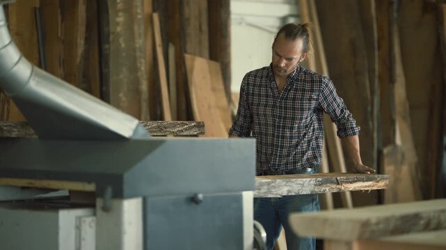 Carpenter using a thickness planer machine
