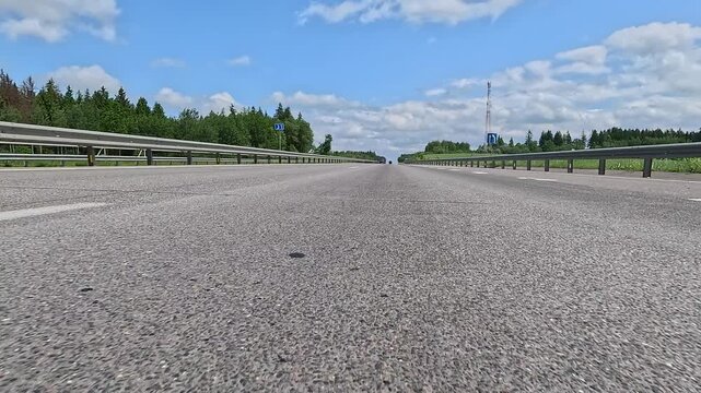 Video shooting in motion, driving a red car over the road along the asphalt at speed, view from the wheel.