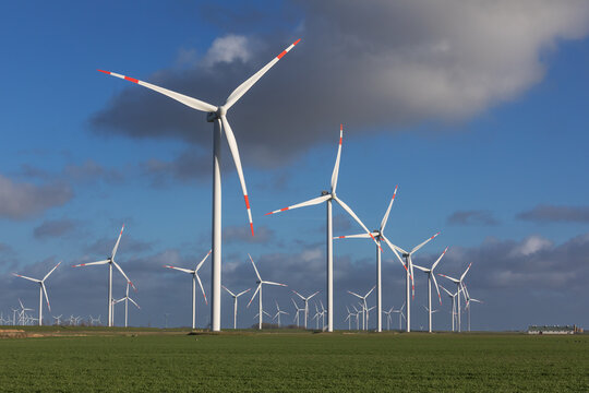 Windr&auml;der in einem Windpark bei Reu&szlig;enk&ouml;ge an der Nordsee in Nordfriesland, Schleswig-Holstein, Deutschland, bei teilweise bew&ouml;lktem Himmel.