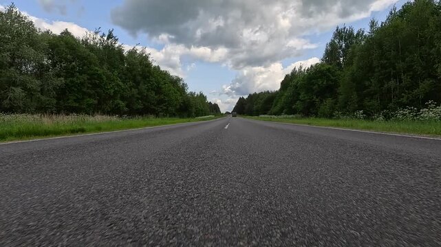 Video shooting in motion, driving a red car over the road along the asphalt at speed, view from the wheel.