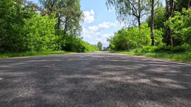 Video shooting in motion, driving a red car over the road along the asphalt at speed, view from the wheel.
