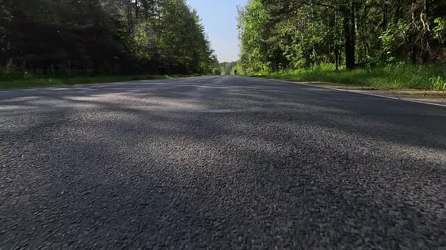 Video shooting in motion, driving a red car over the road along the asphalt at speed, view from the wheel.