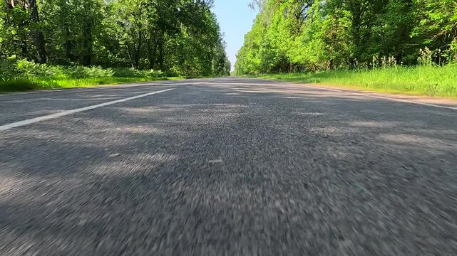 Video shooting in motion, driving a red car over the road along the asphalt at speed, view from the wheel.