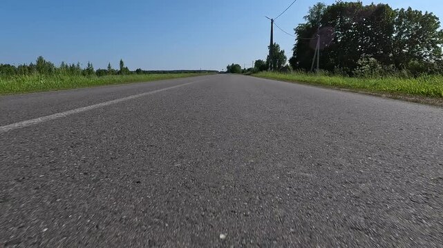 Video shooting in motion, driving a red car over the road along the asphalt at speed, view from the wheel.