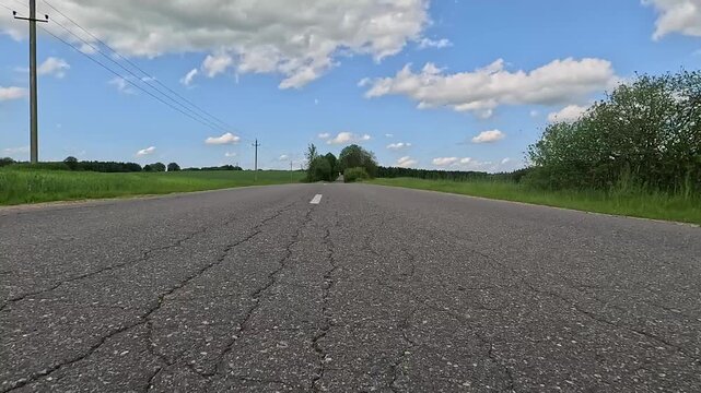 Video shooting in motion, driving a red car over the road along the asphalt at speed, view from the wheel.