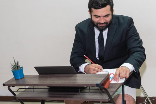 Businessman working remotely in suit and shorts