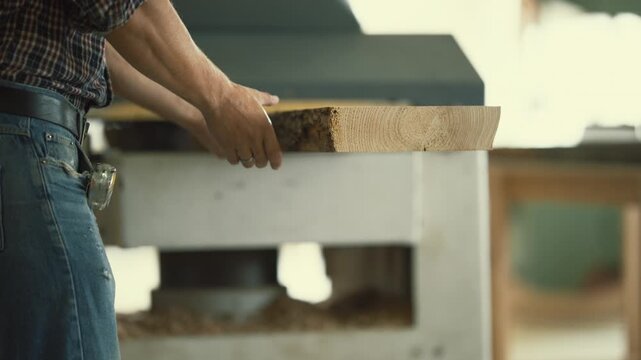 Carpenter processing wood plank using thickness planer machine