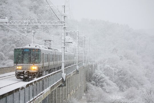 激しい雪の中を走行するJR西日本の新快速電車