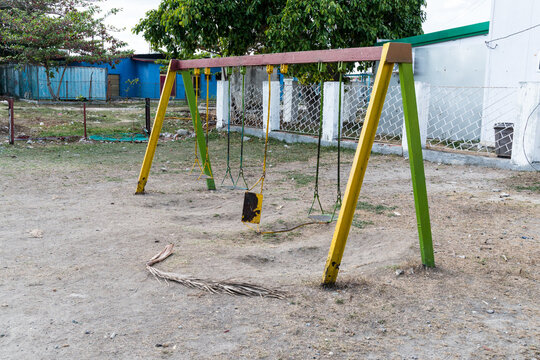 Cuba, Cienfuegos.  A forlorn looking swing set in children's playground.