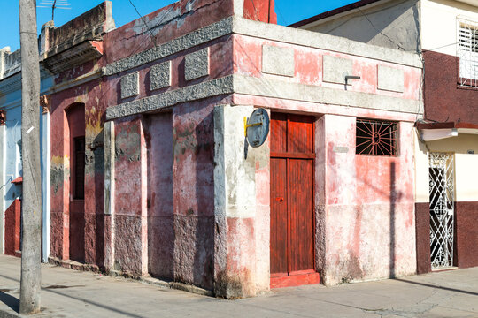 Cuba, Cienfuegos.  A curious red, block-like building on the corner.  Formerly a storefront, now used as residential.