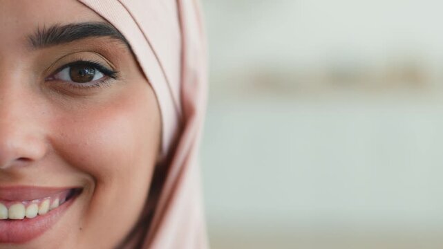 Close up positive smiling Indian Muslim woman wearing hijab showing healthy teeth at home happy satisfied half face joyful Arabian female Islamic girl lady looking at camera Islam religion indoors