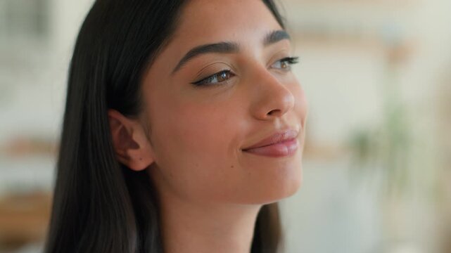 Happy playful Arabian Indian woman at home smiling showing tongue funny grimace looking at camera joyful girl humor pretty Hispanic female having fun silly face cheerful mood cute expression indoors