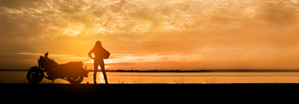 Banner Silhouette Motorcycle sunset golden sky background. Panorama Motorbike park garden outdoors lake view reflection sunbeam at dawn. Silhouette Motorcycle biking golden landscape with copy space