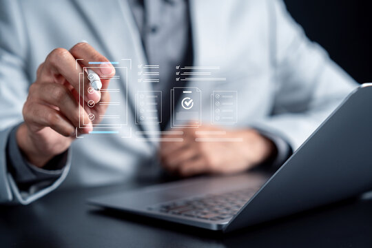 Businessman pointing at digital checklist hologram. Paperless office, quality control and compliance business concept.