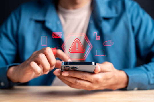 Person using smartphone with warning sign and cyber security digital icon. Scam alert, phishing and data breach concept.