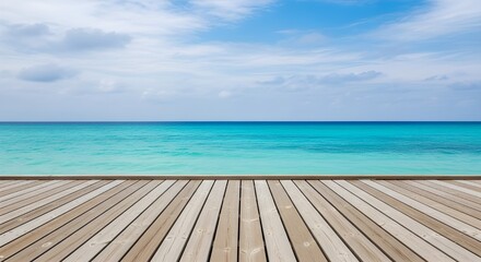 Fototapeta premium Serene beach vista a wooden boardwalk leads to turquoise waters under a bright cloud speckled sky