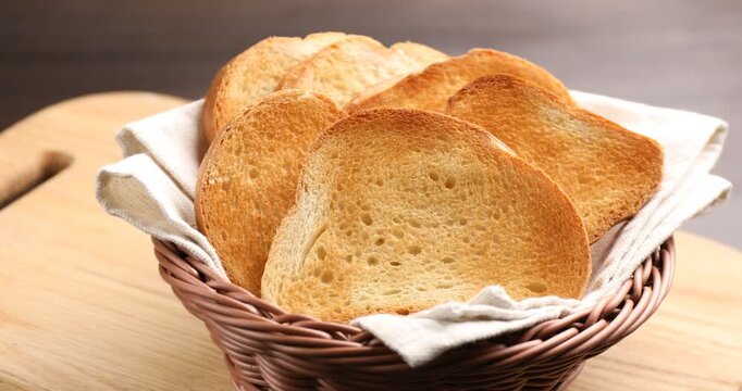 Browned toast bread slices in wicker basket on table, closeup