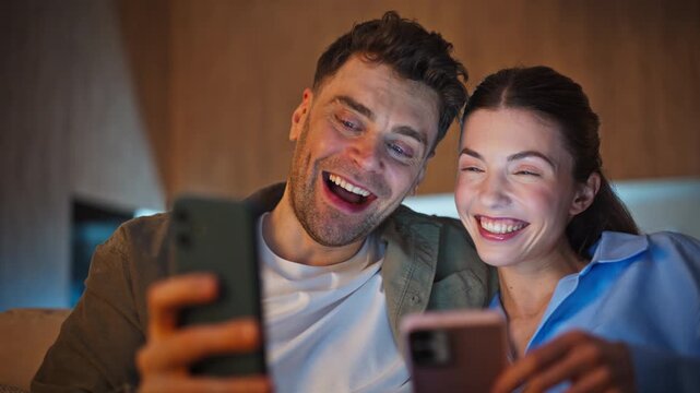 Cellphones users looking screens late room closeup. Happy couple smartphones