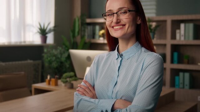 Joyful smiling Caucasian redhead business woman with crossed arm indoor office confident businesswoman girl female entrepreneur in eyeglasses looking at camera manager leader saleswoman toothy smile