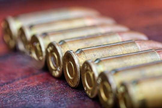 Close-up of 9mm Brass Pistol Ammunition in a Row ammunition in the foreground and background.