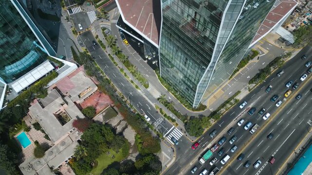 Cinematic drone perspective of the Westin skyscraper entrance and the busy intersection of Javier Prado, capturing the modern street layout of San Isidro.