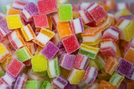 Close-up of multi-colored sugar-coated jelly candies. These sweet, chewy, layered rainbow treats are perfect for parties, desserts, and sugary snack concepts.