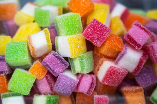 Close-up of multi-colored sugar-coated jelly candies. These sweet, chewy, layered rainbow treats are perfect for parties, desserts, and sugary snack concepts.