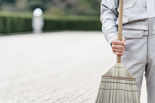 ほうきを持つ作業員
