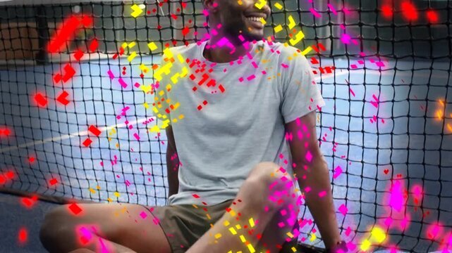 Sport athlete placing yellow ball on paddle pushing up on court posing for camera confetti floating