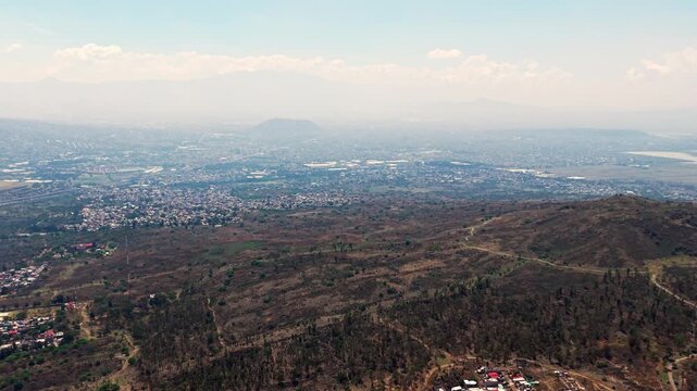 High altitude aerial perspective of a metropolitan valley meeting the mountain range, 4K High Quality.