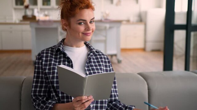 Caucasian woman choosing color palette for apartment renovation home smiling sofa happy female homeowner writing notes planning interior house design colorful samples creative girl looking at camera